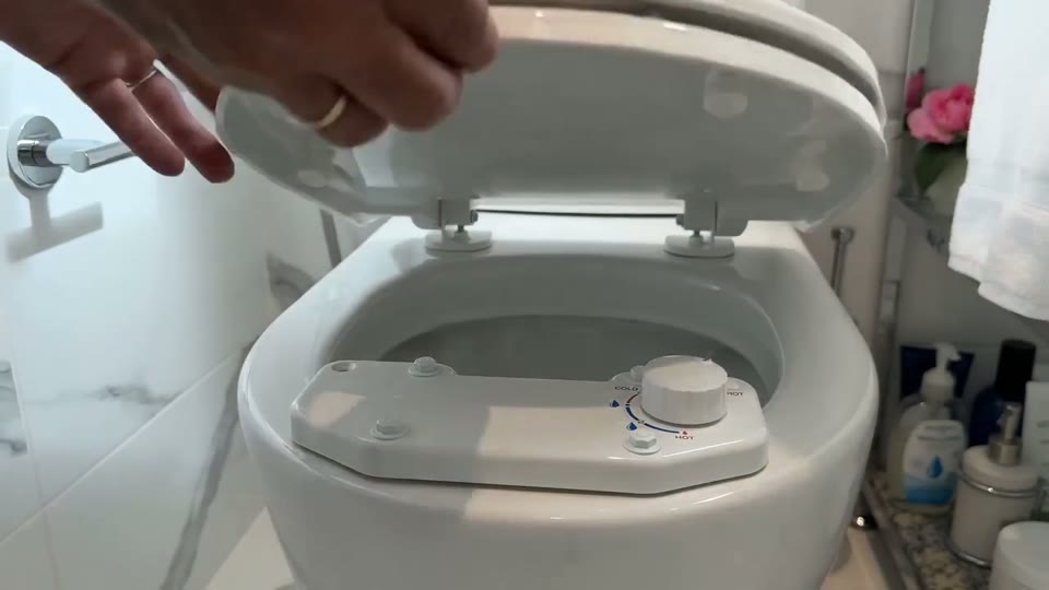 Sample clip poster: hands setting a bidet attachment plate under a toilet seat